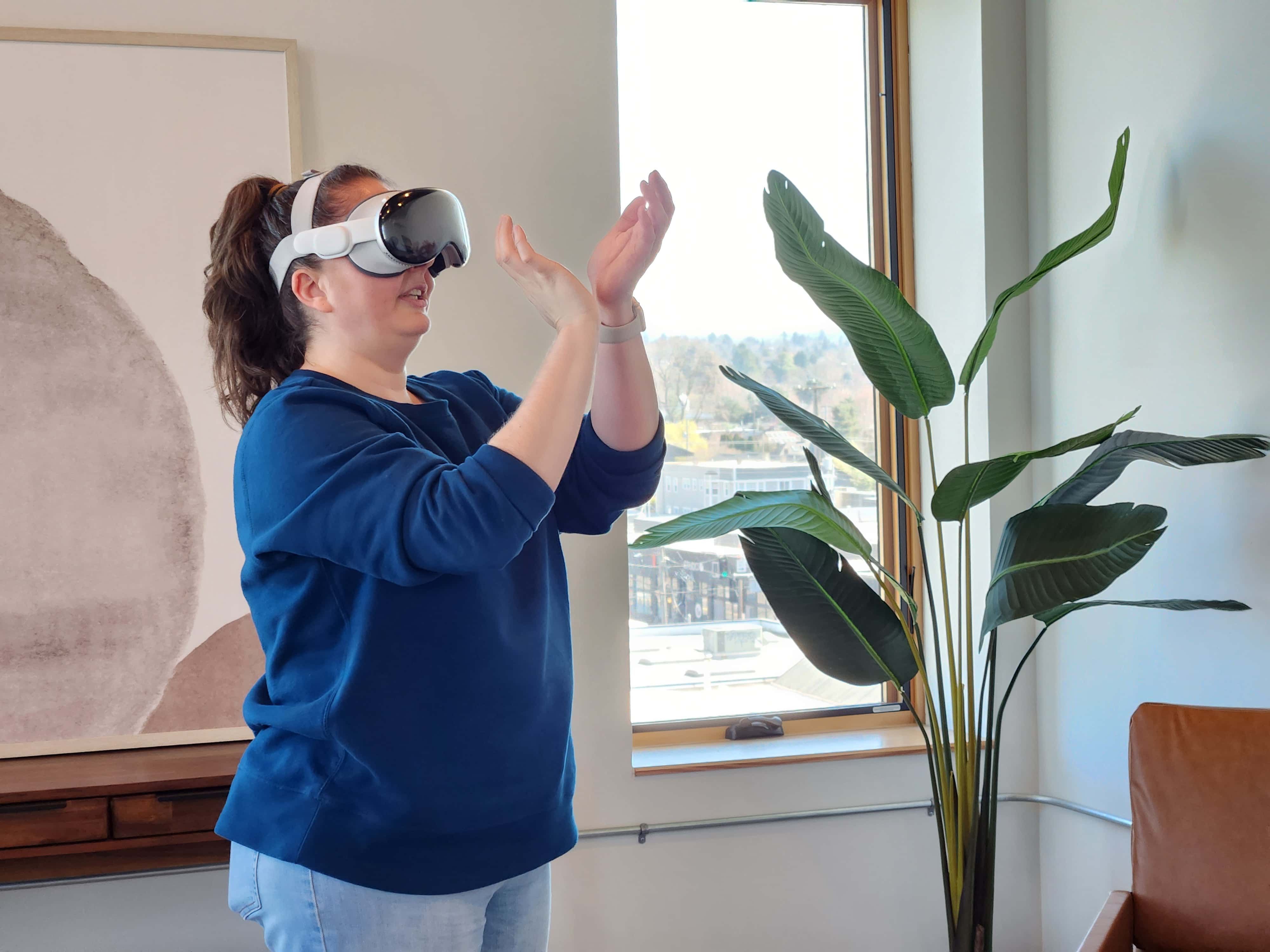 A person wearing an Apple Vision Pro. Their hands are up as if holding a virtual basketball, ready to shoot a basket.
