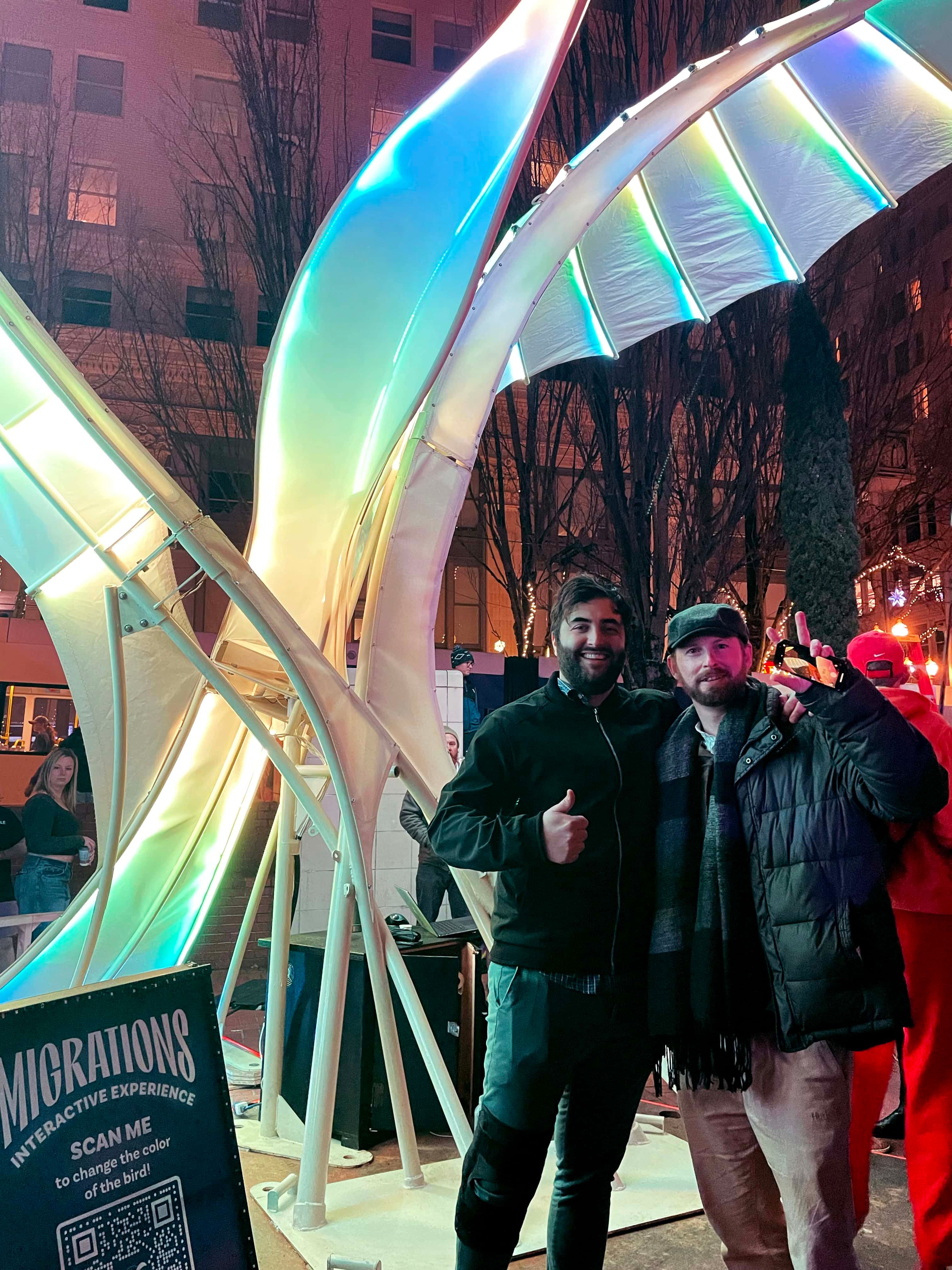 Two people standing in front of an illuminated art sculpture.