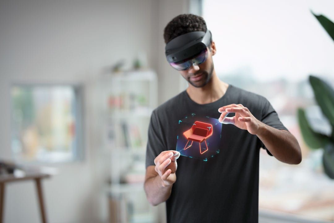 Person wearing Hololen headset and interacting with digital overlays.