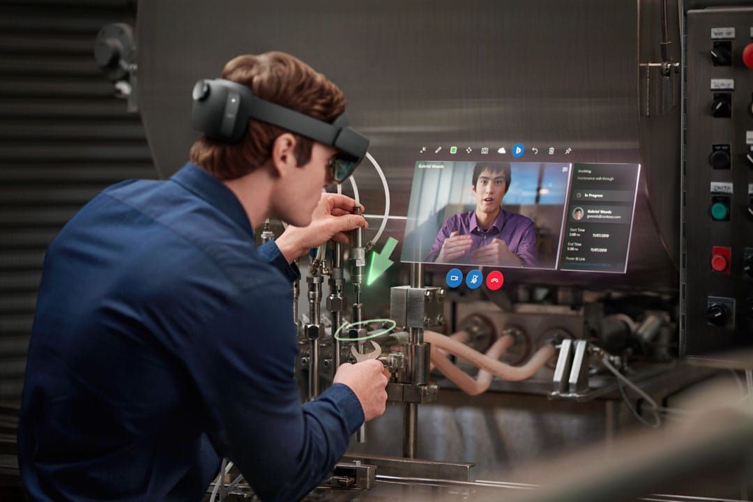 People wearing Hololens headsets and interacting with digital overlays.