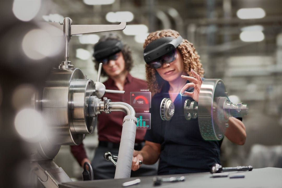 People wearing Hololens headsets and interacting with digital overlays.